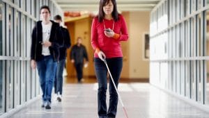 A blind woman navigates with a stick